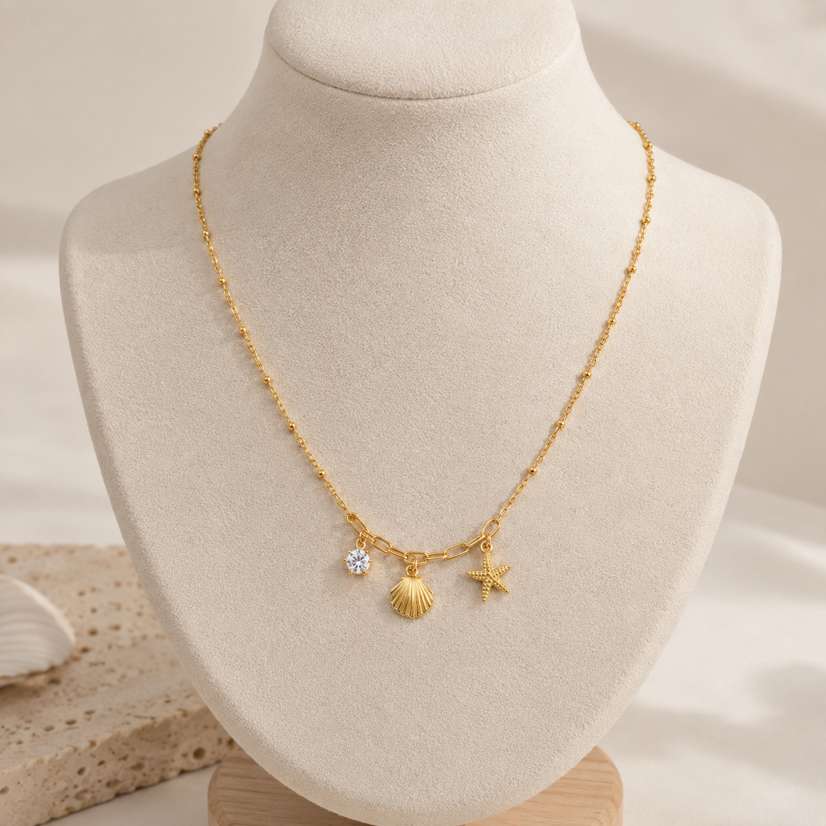 Close-up of starfish, seashell and zircon charms on a gold necklace