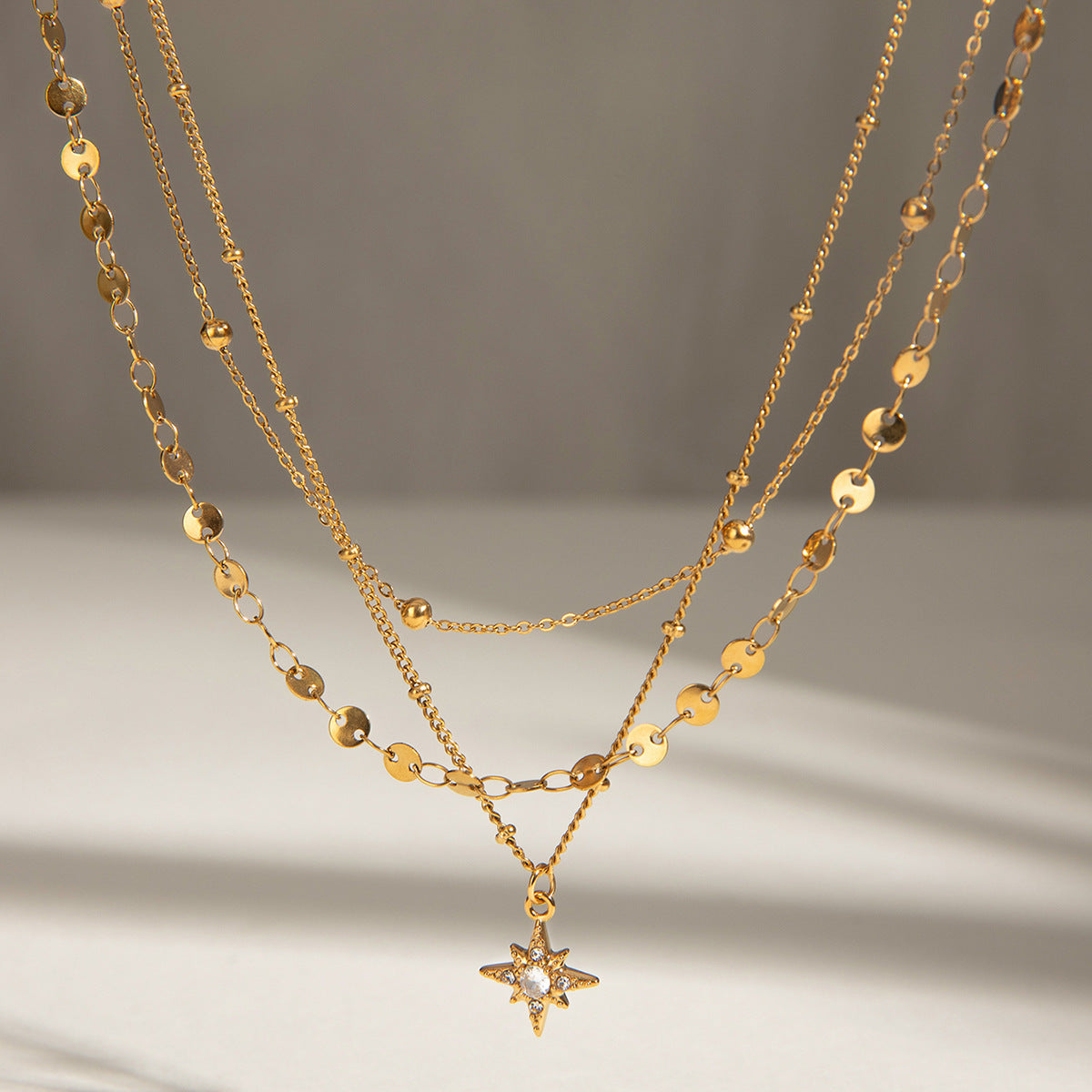 Close-up of gold Celeste Layered Eight-Point Star Necklace